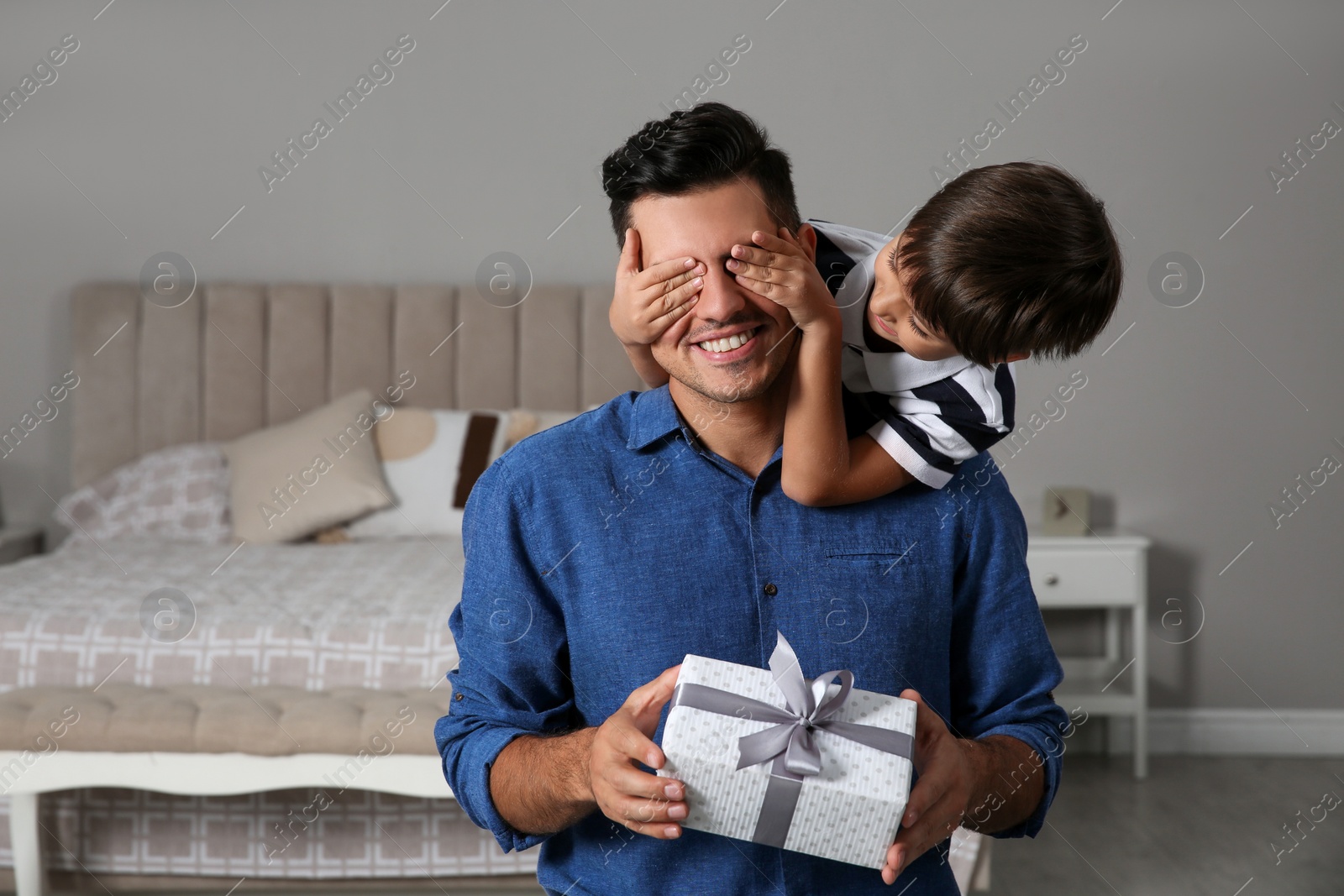 Photo of Man receiving gift for Father's Day from his son at home