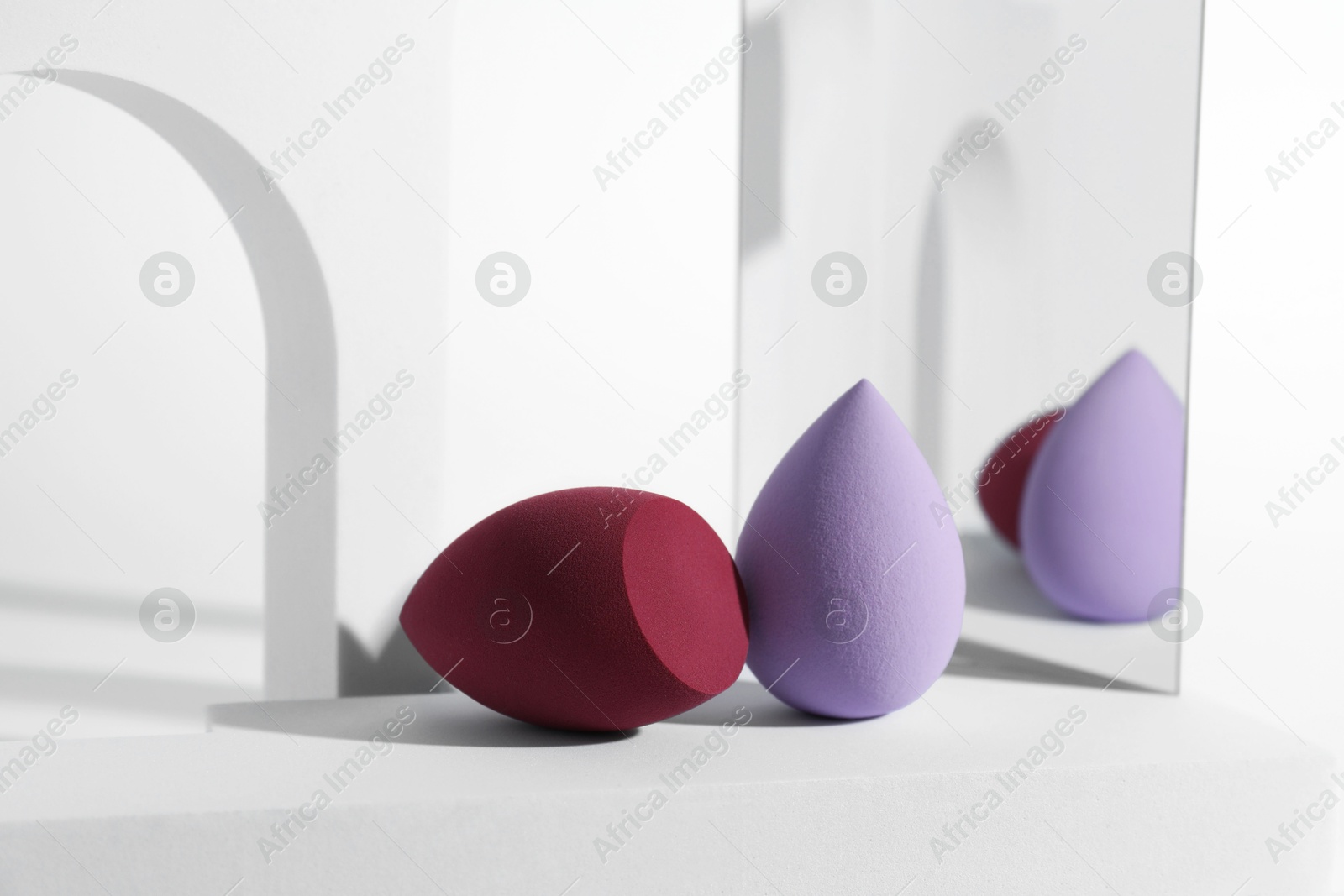 Photo of Stylish presentation of makeup sponges on white background