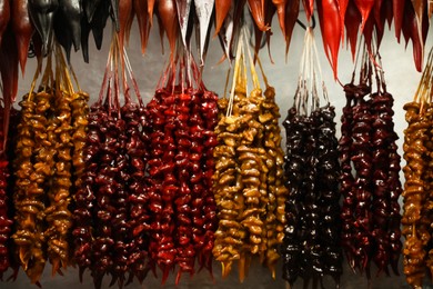 Photo of Bunches of different delicious churchkhelas at market