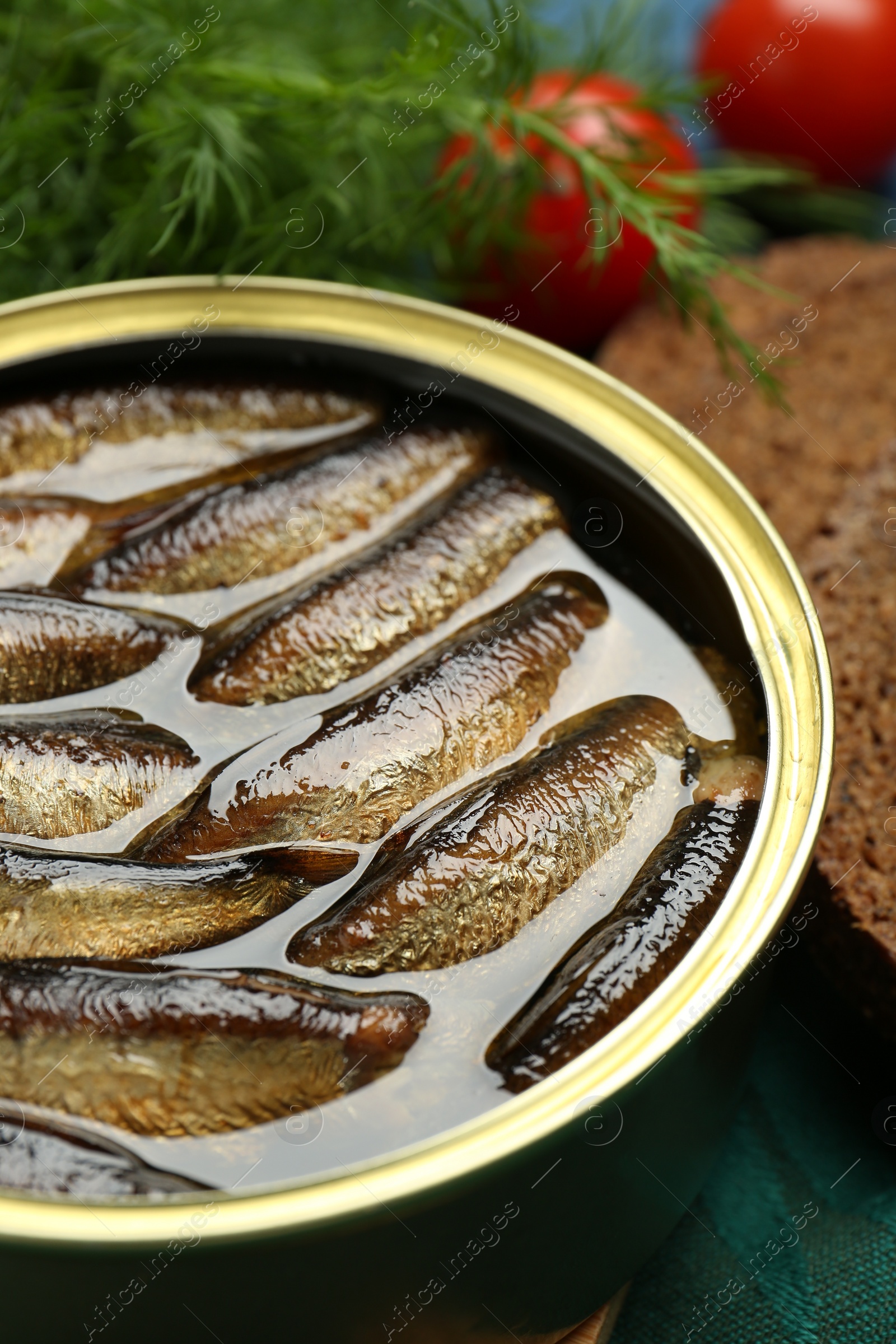 Photo of Tin can with tasty sprats on table, closeup