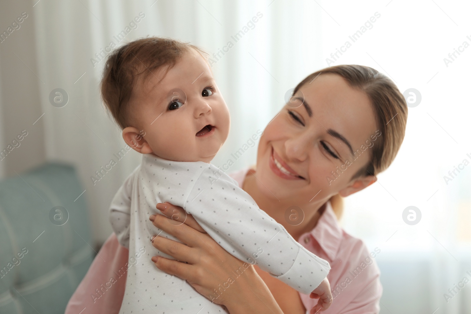 Photo of Young woman with her cute baby at home