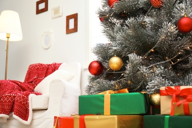 Photo of Stylish room interior with beautiful Christmas tree and gift boxes