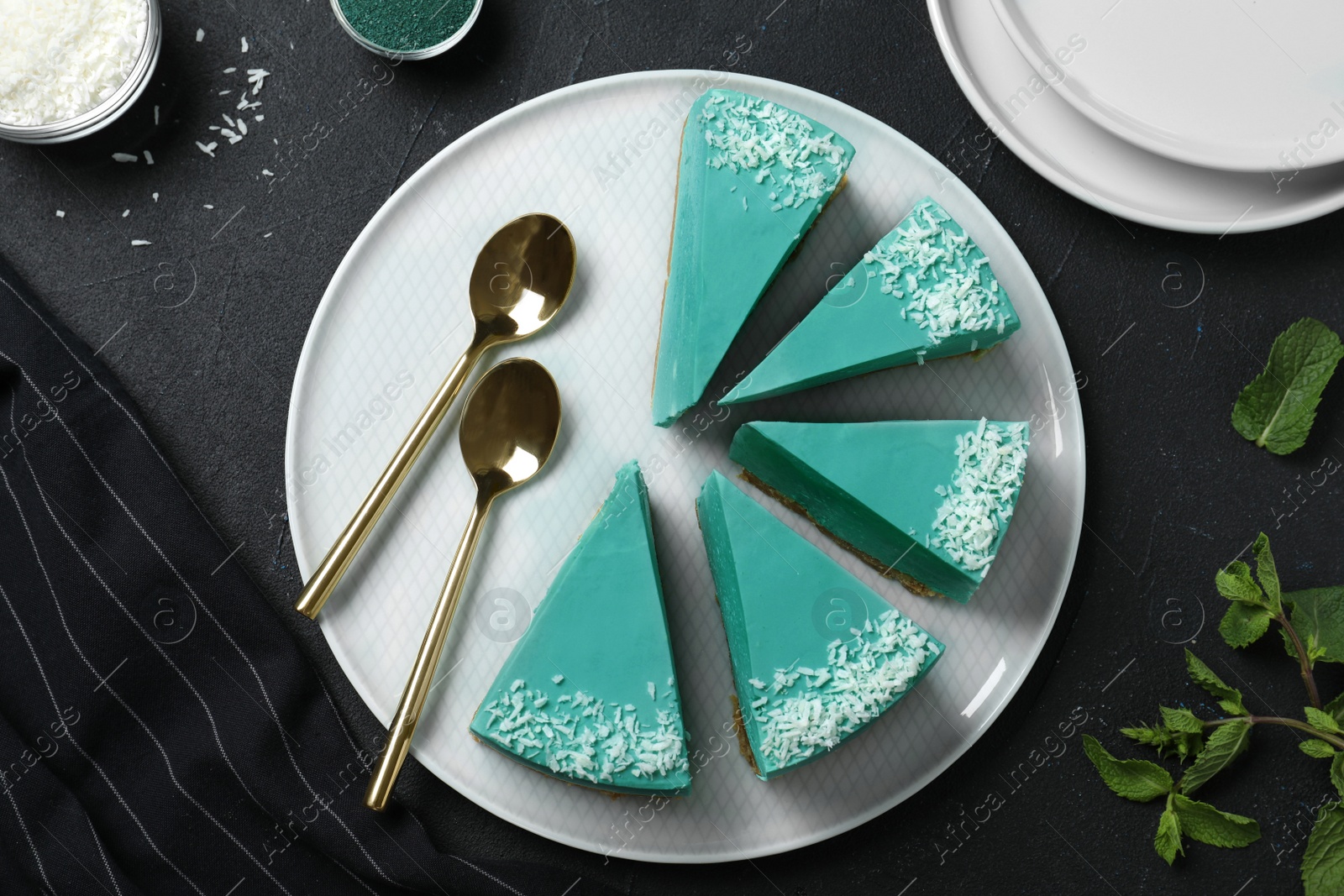 Photo of Flat lay composition with tasty spirulina cheesecake on dark table