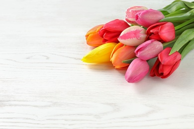 Photo of Beautiful spring tulip flowers on wooden background. Space for text