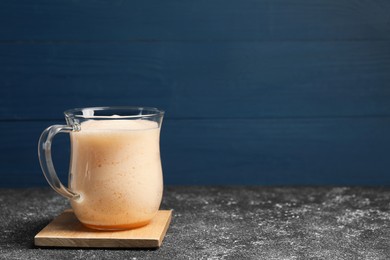 Photo of Delicious eggnog on grey table. Space for text