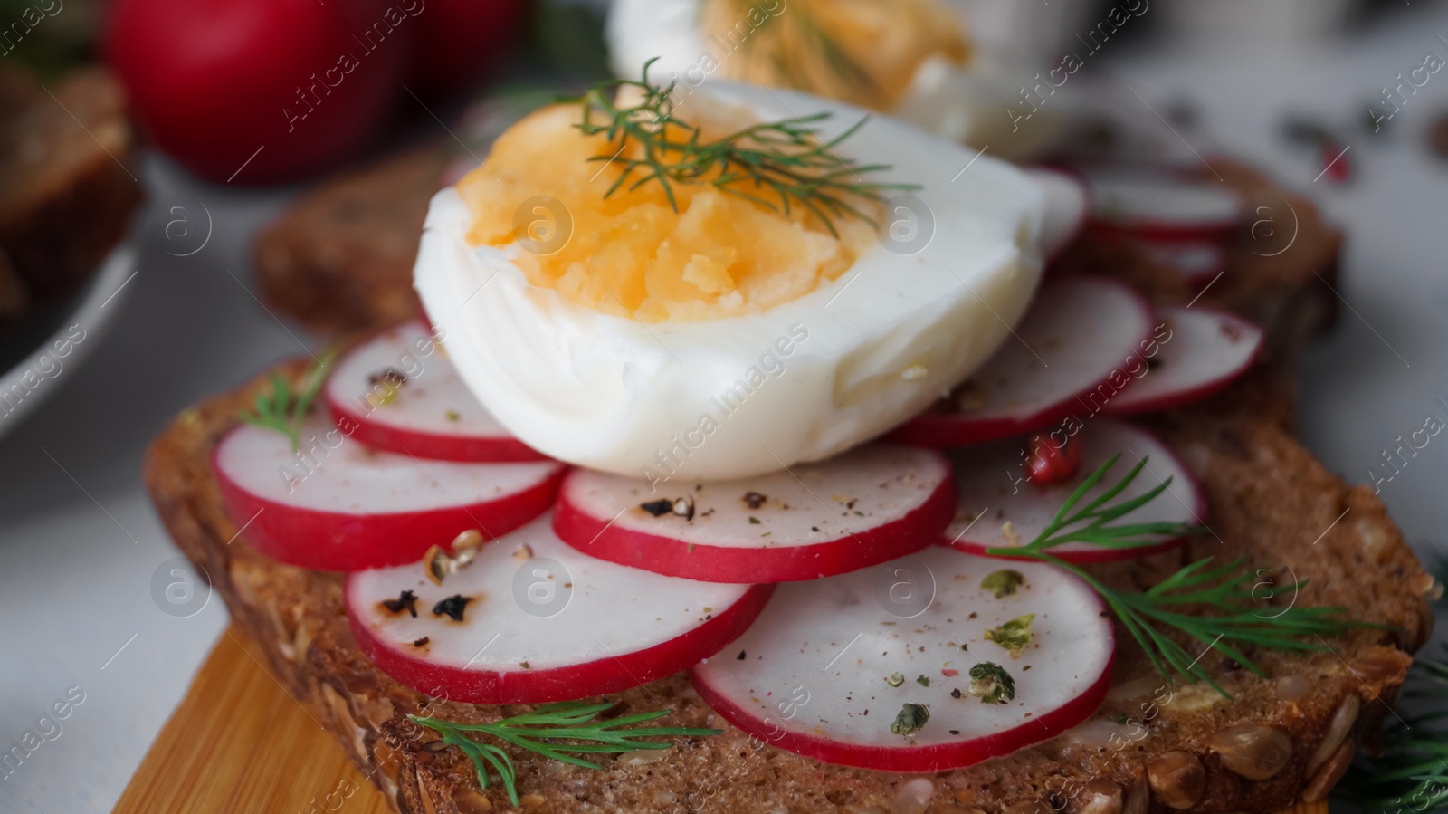 Photo of Tasty sandwich with boiled egg and radish on table, closeup