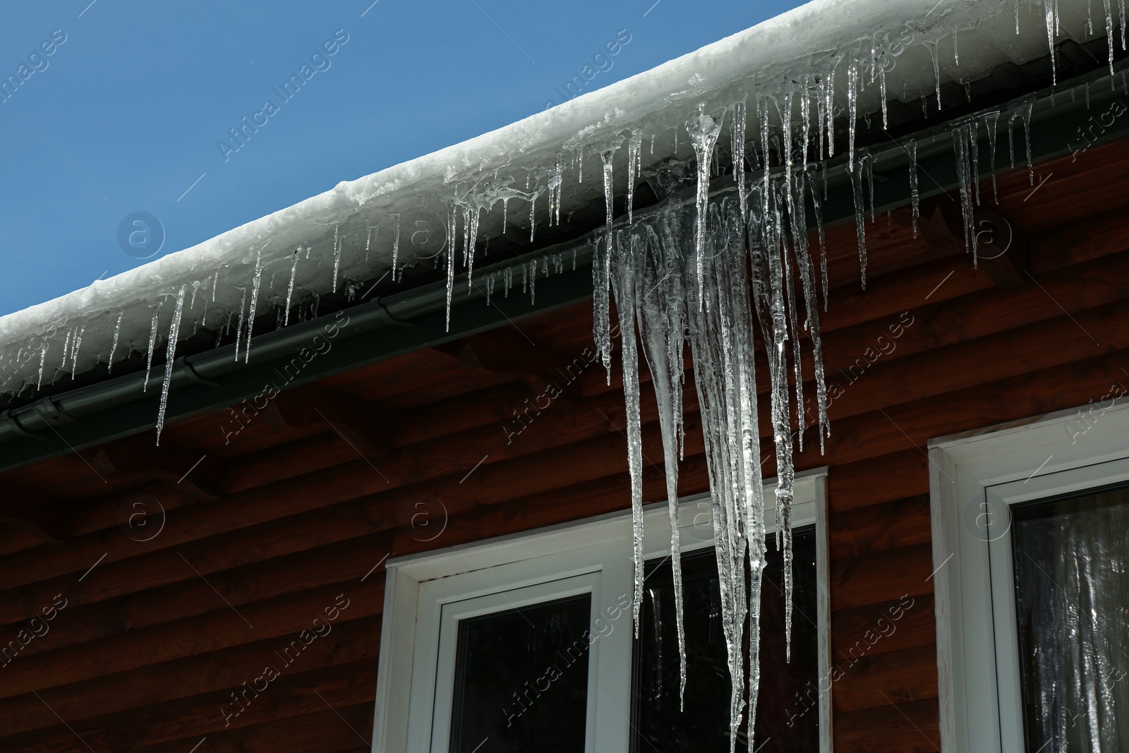 Photo of House with icicles on roof. Winter season