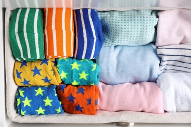 Photo of Many different colorful socks in open drawer, top view