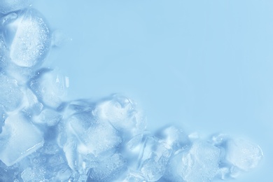 Photo of Melting ice cubes on color background, top view. Space for text