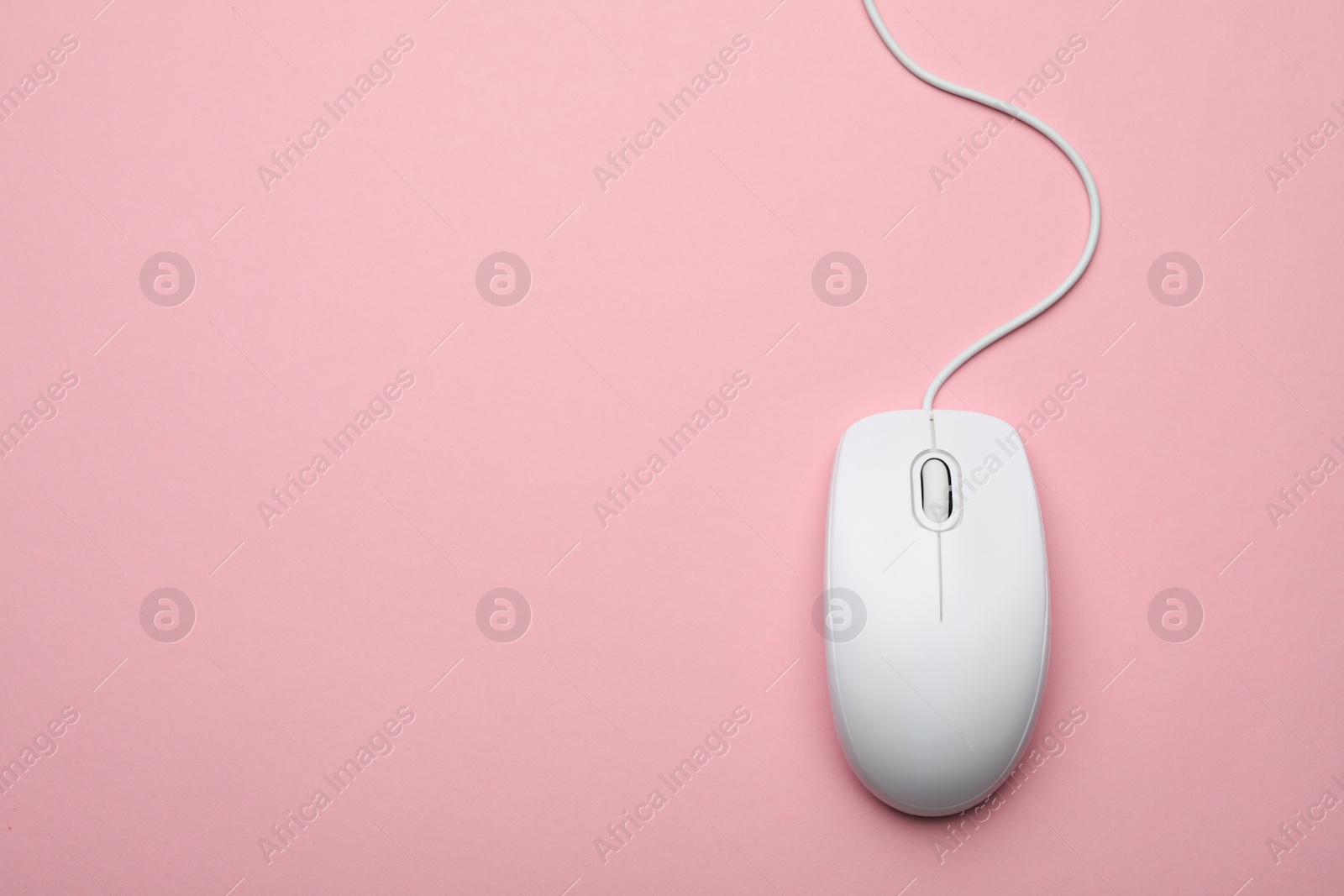 Photo of Wired computer mouse on pink background, top view. Space for text