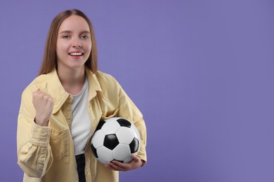 Photo of Happy sports fan with ball on purple background. Space for text