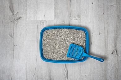 Litter tray and scoop for cat on floor, top view. Pet care