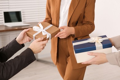 Photo of Colleague presenting gifts to man in office, closeup