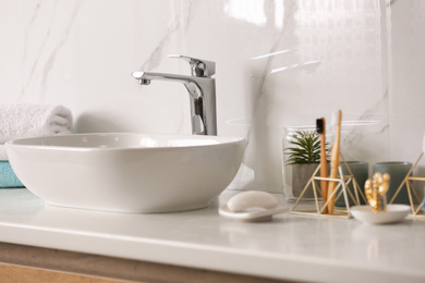 Stylish vessel sink on light countertop in modern bathroom