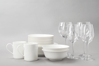 Photo of Set of clean tableware on grey background. Washing dishes