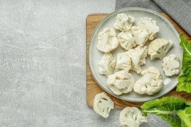 Photo of Cut fresh raw cauliflowers on grey table, top view. Space for text