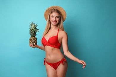 Photo of Pretty young woman wearing stylish bikini with pineapple on blue background