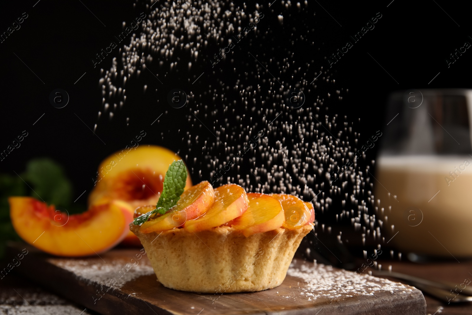 Photo of Decorating delicious peach dessert with powdered sugar on wooden board