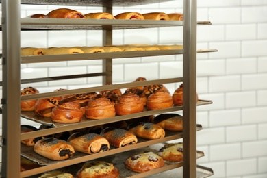 Rack with fresh pastries in bakery workshop