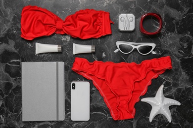 Photo of Flat lay composition with smartphone and beach objects on dark background