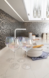Photo of Beautiful ceramic dishware and glasses on countertop in modern kitchen