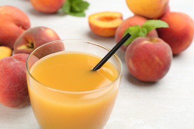 Photo of Natural freshly made peach juice on white table, closeup