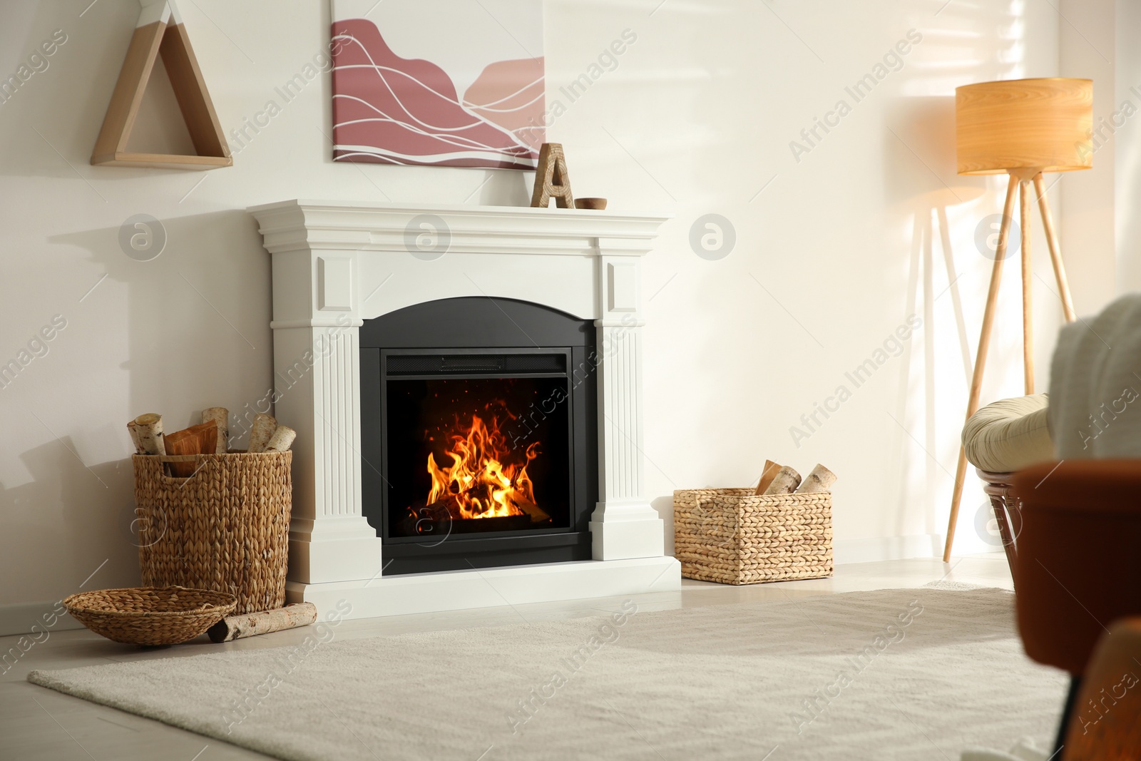 Photo of Bright living room interior with fireplace and baskets of firewood