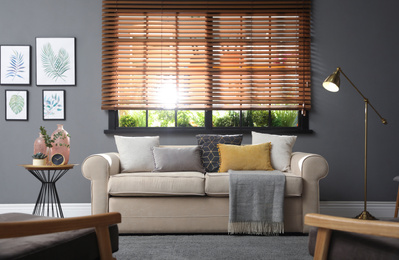 Stylish living room interior with comfortable sofa near window