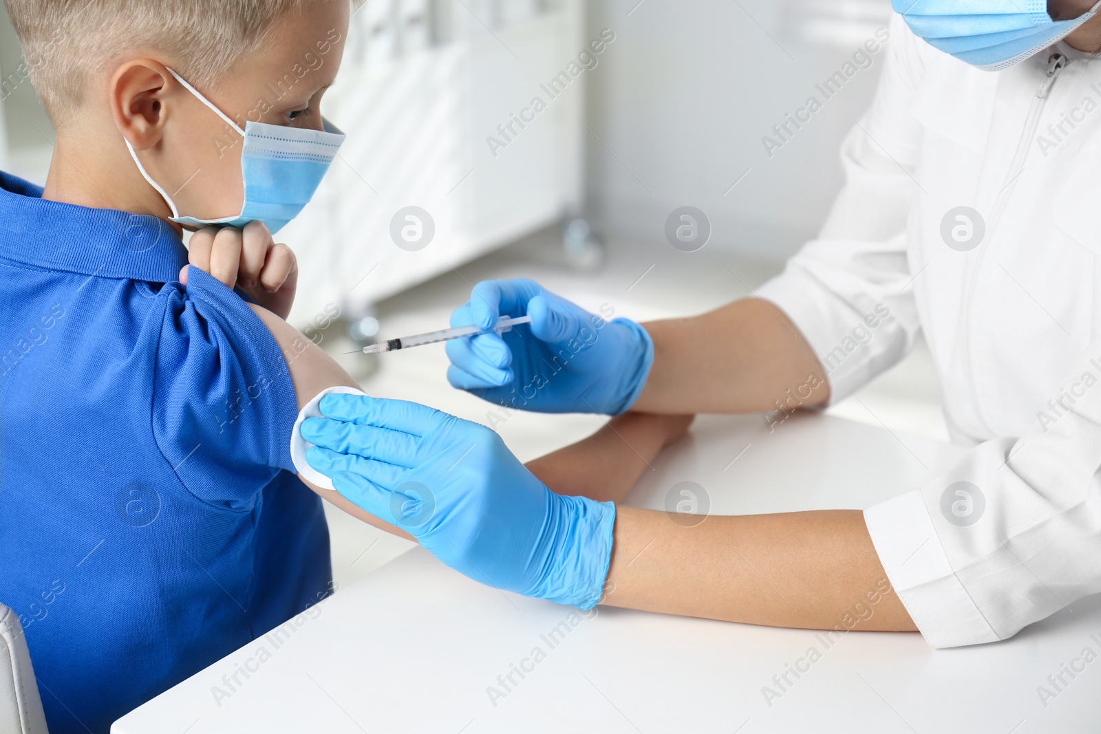 Photo of Doctor vaccinating little boy in hospital. Health care