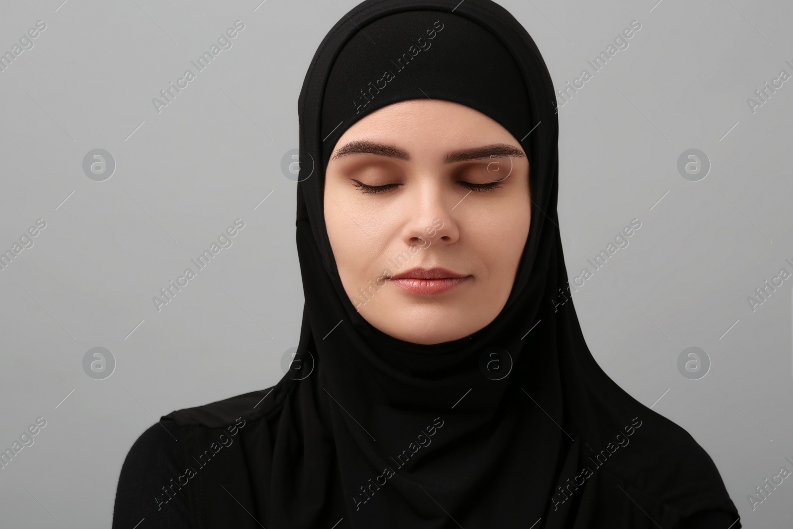 Photo of Portrait of Muslim woman in hijab on light gray background