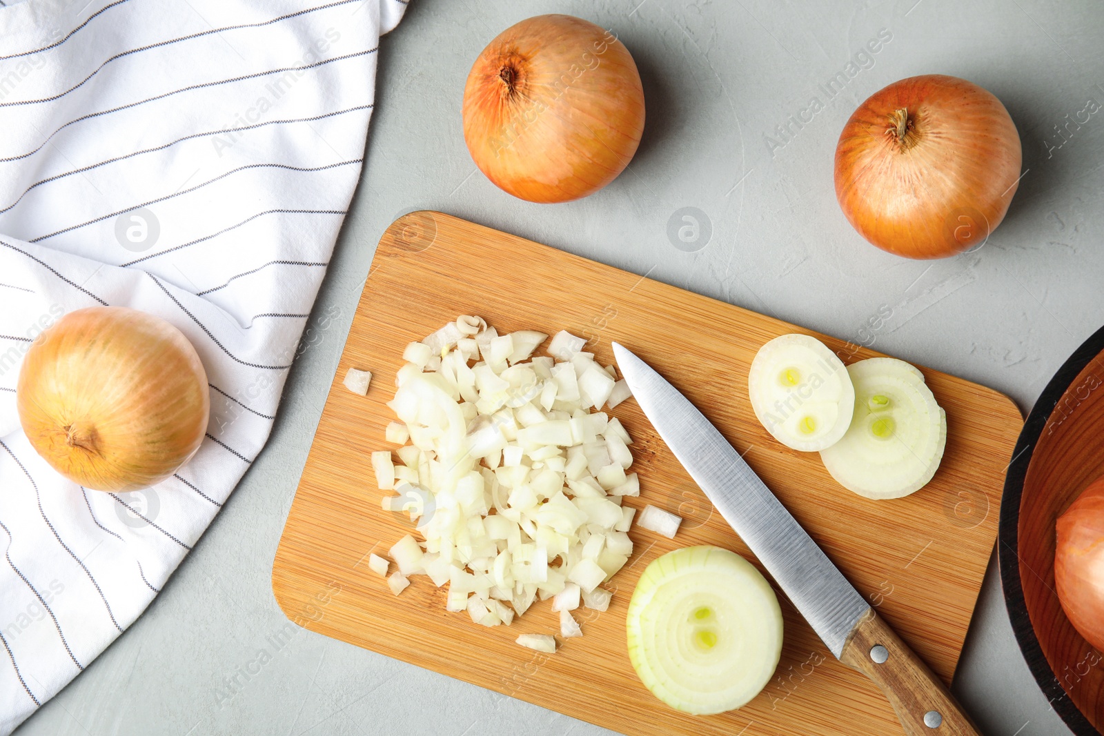 Photo of Flat lay composition with chopped and whole onions on grey table