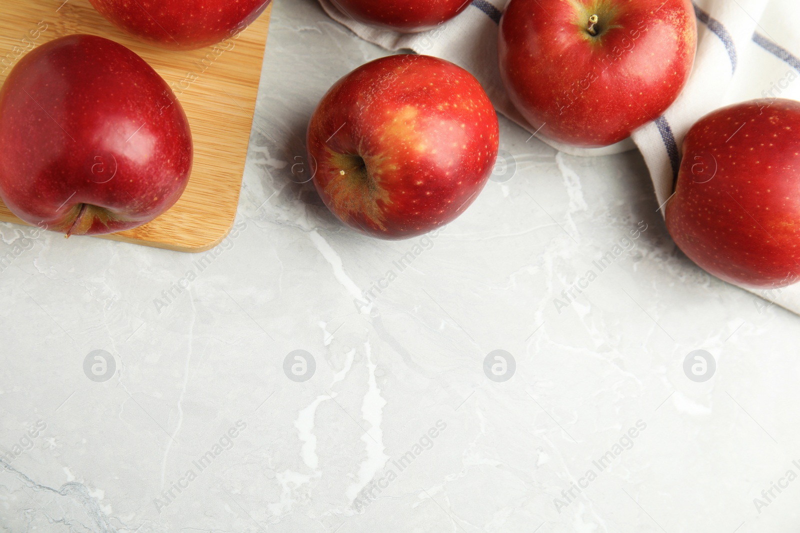 Photo of Ripe juicy red apples on grey background, flat lay. Space for text