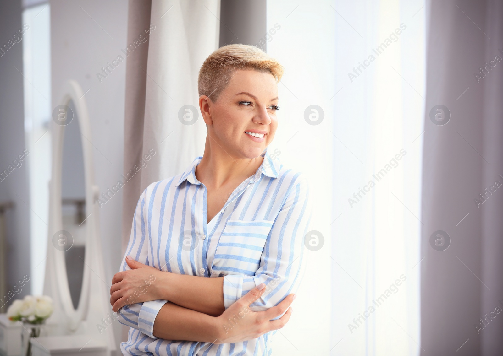 Image of Portrait of beautiful woman near window at home