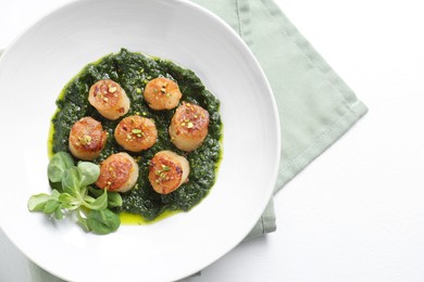 Photo of Delicious fried scallops with tasty sauce and corn salad in bowl on white table, top view