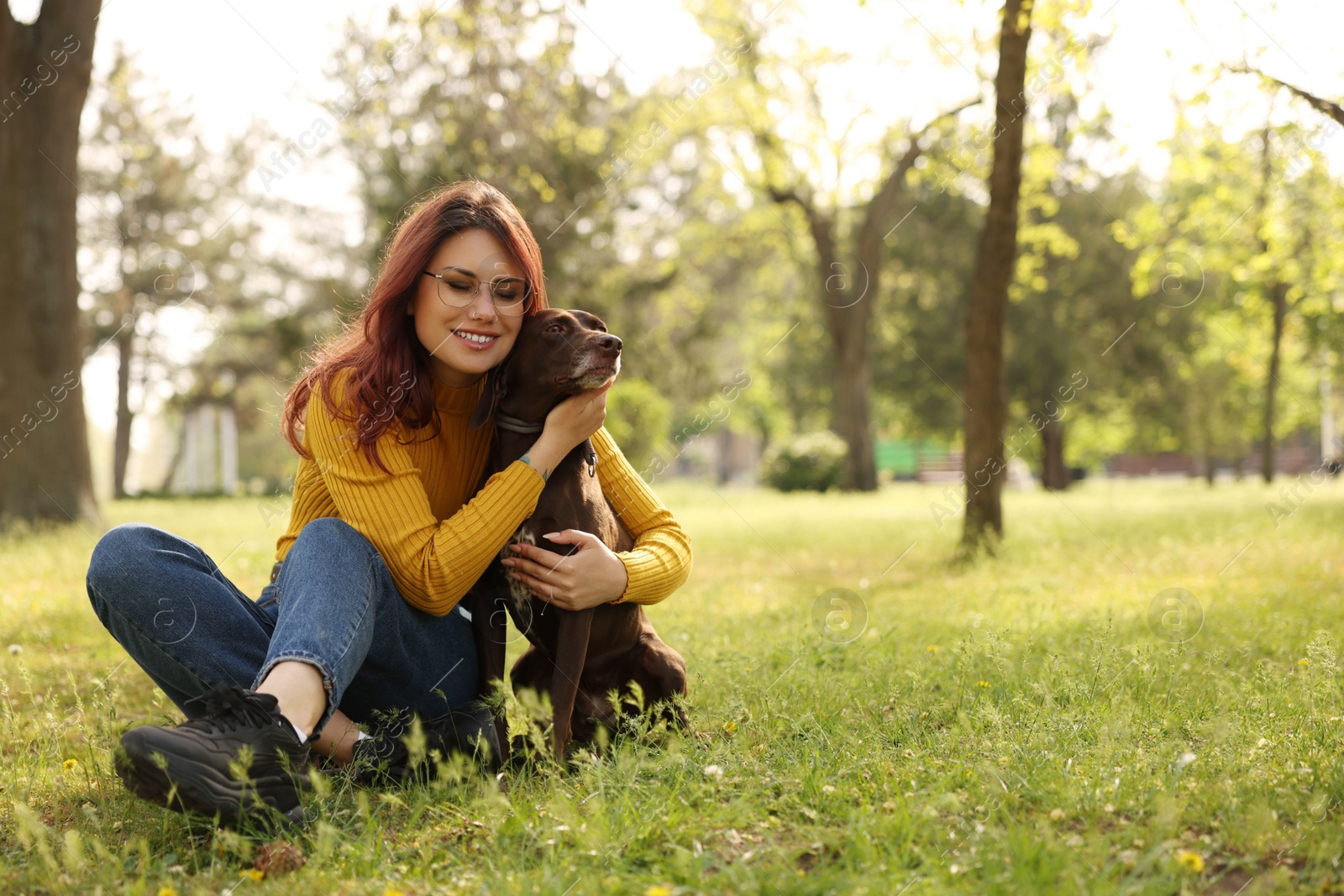 Photo of Woman with her cute German Shorthaired Pointer dog in park on spring day