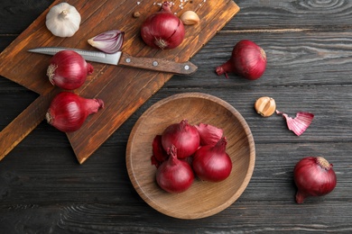 Flat lay composition with ripe red onions on wooden table