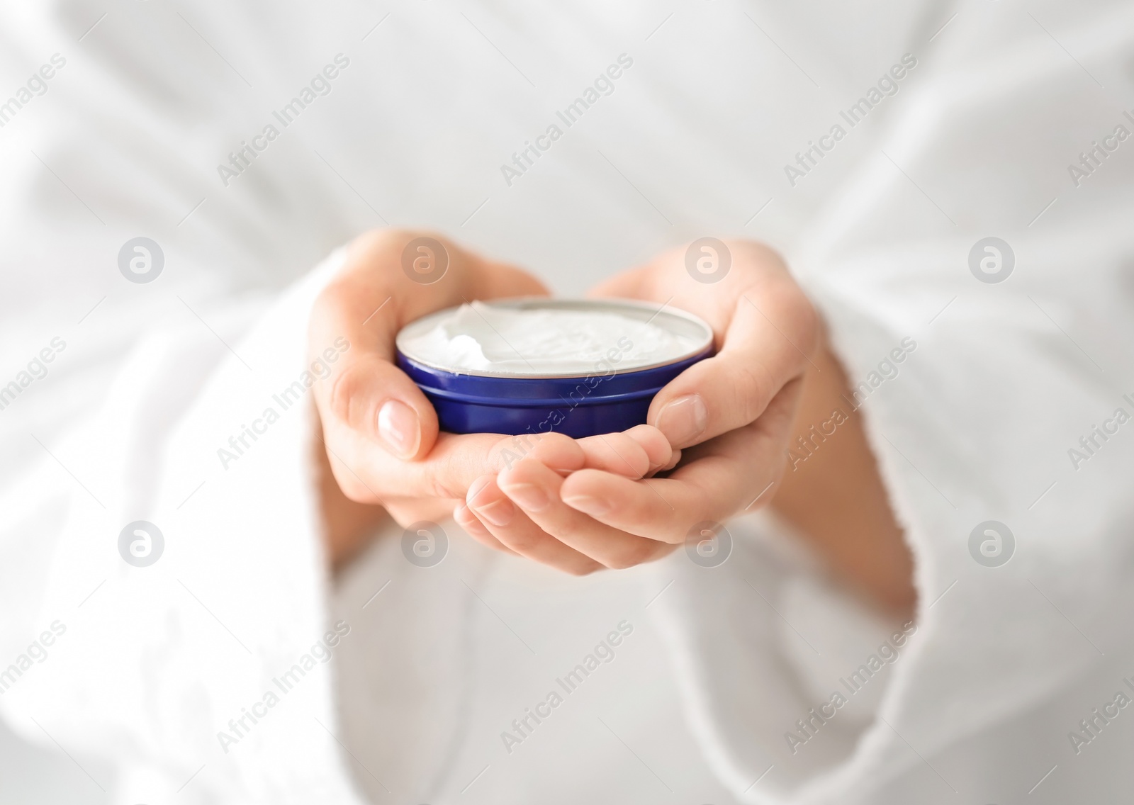 Photo of Young woman holding jar with hand cream, closeup