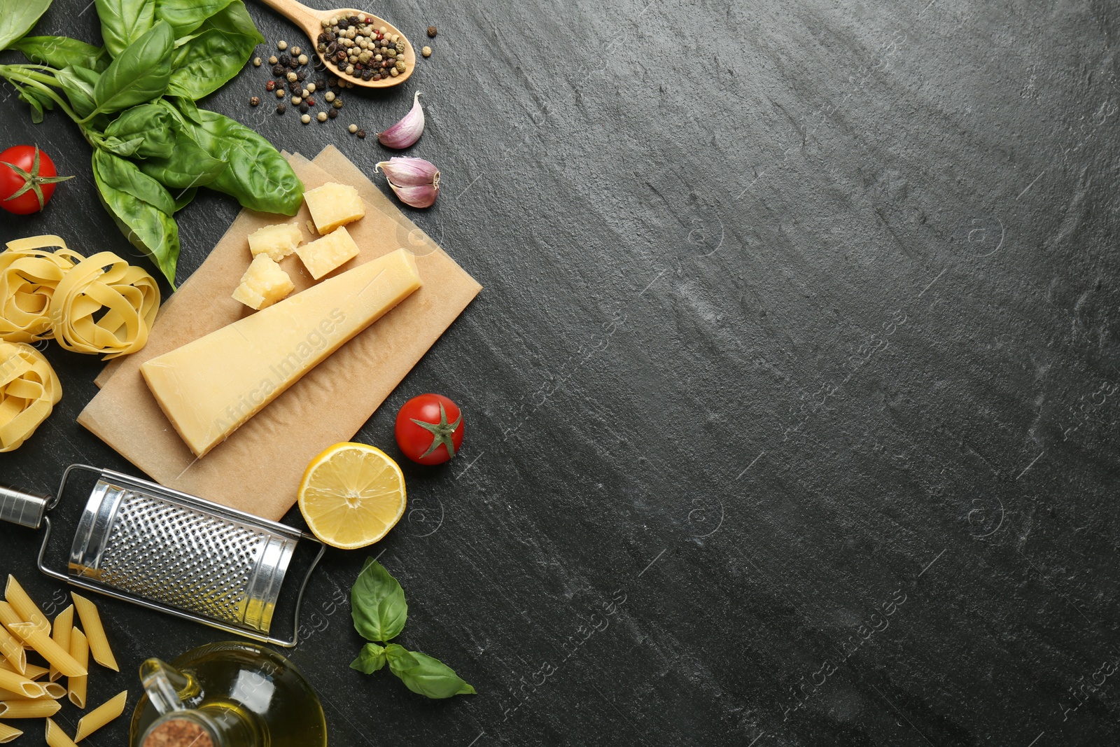 Photo of Different types of pasta, spices, garter and products on dark textured table, flat lay. Space for text