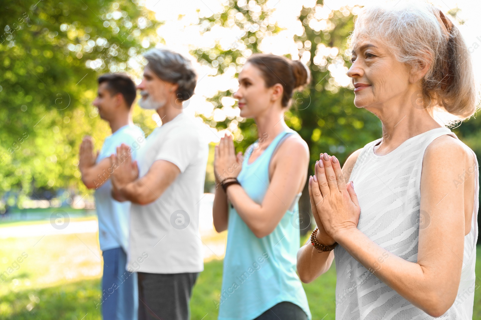 Photo of Group of people practicing morning yoga in park