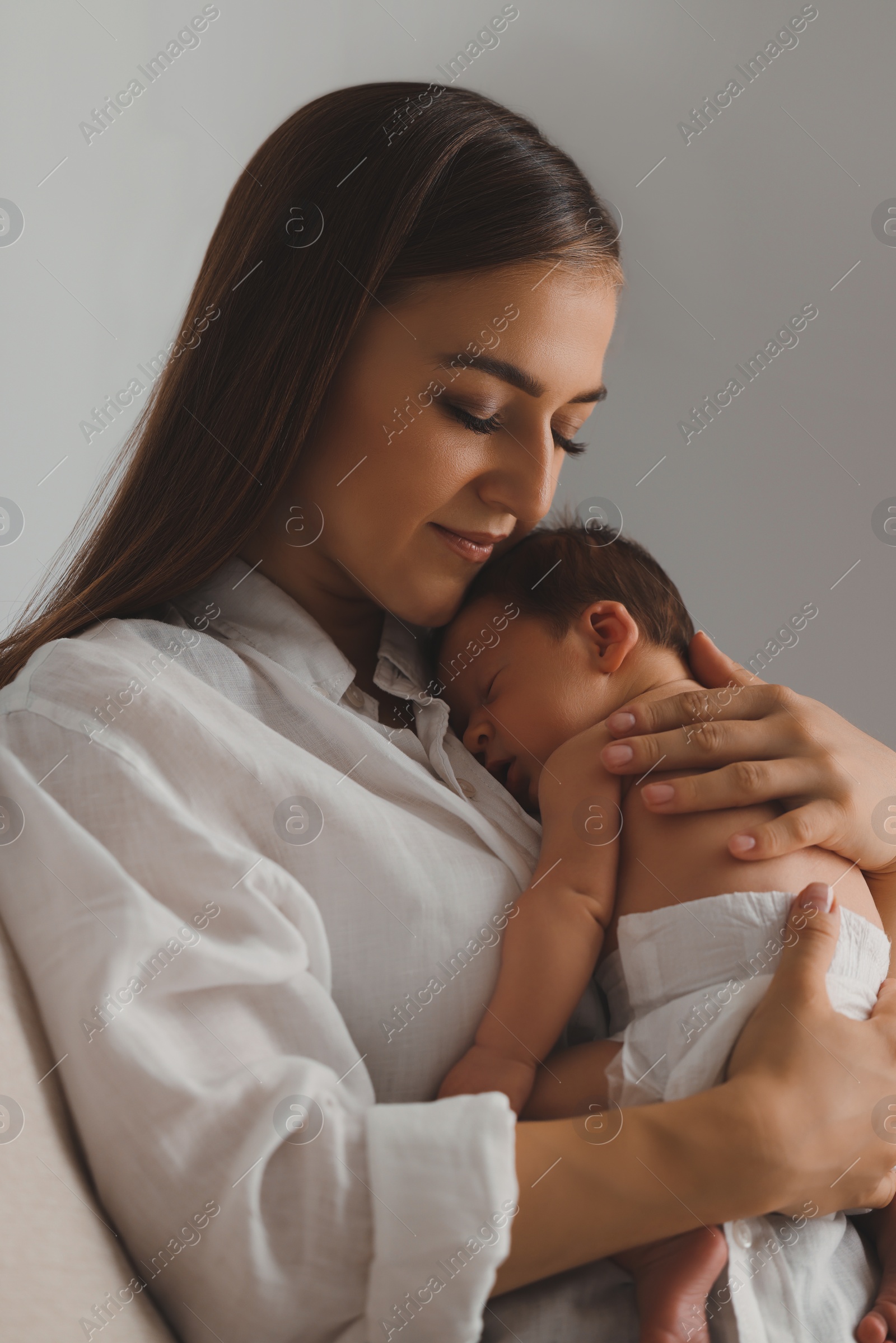 Photo of Mother holding her cute newborn baby indoors