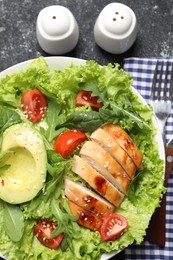 Photo of Delicious salad with chicken, cherry tomato and avocado served on grey textured table, top view