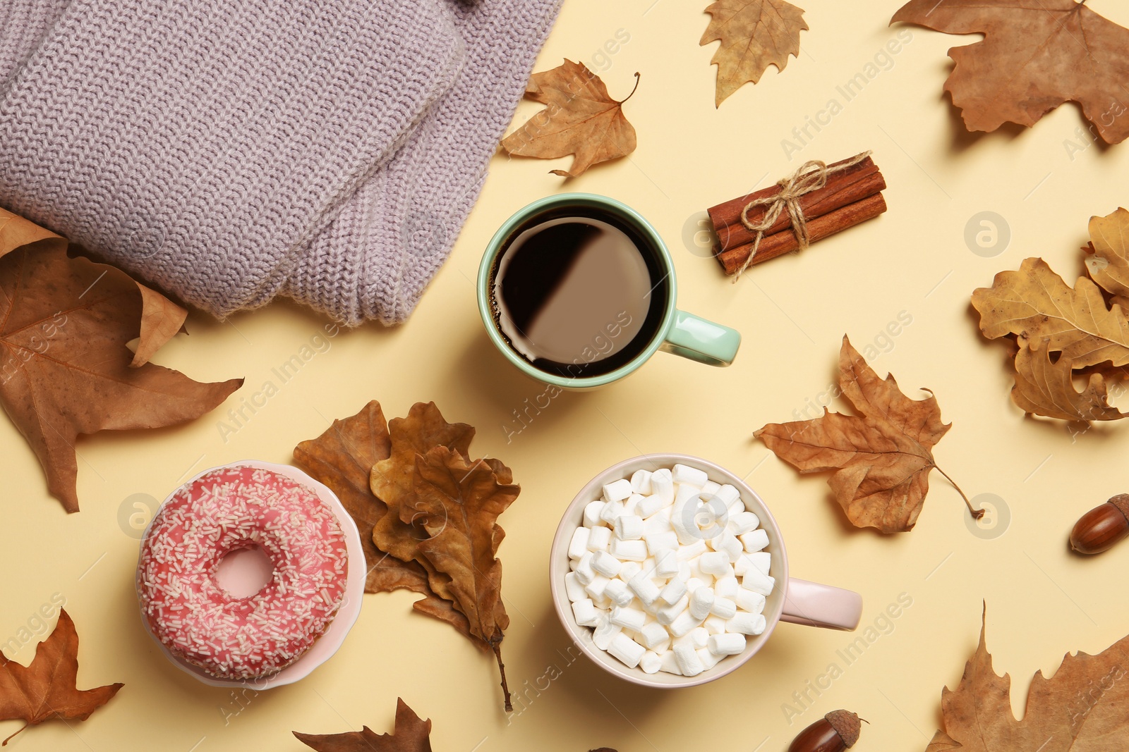 Photo of Flat lay composition with hot cozy drinks and autumn leaves on color background