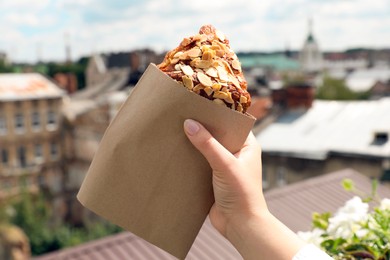 Photo of Woman with delicious croissant outdoors, closeup view