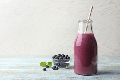 Fresh acai drink with berries on wooden table against light background. Space for text