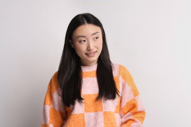 Portrait of smiling woman on light background