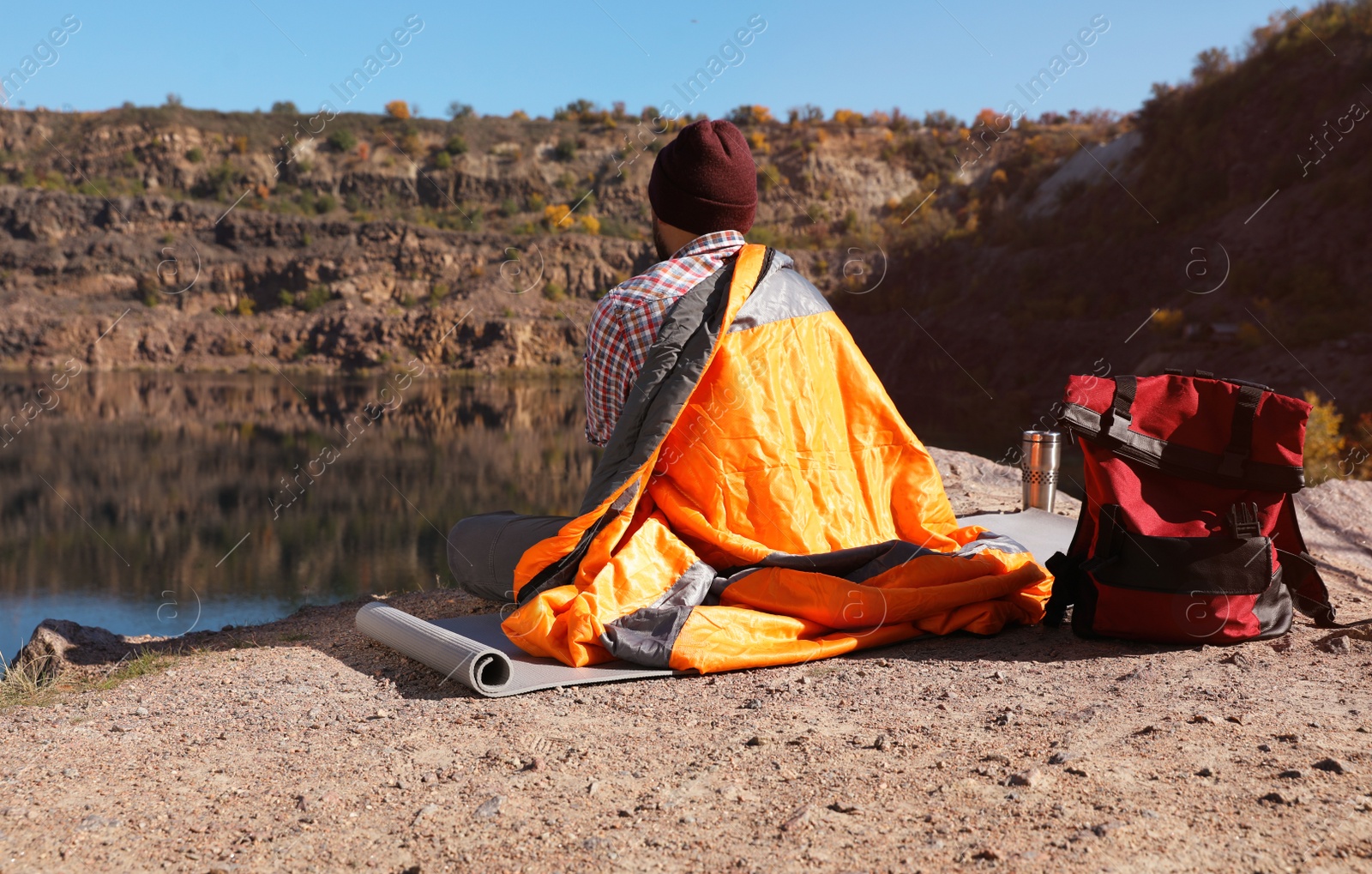 Photo of Male camper with sleeping bag in wilderness