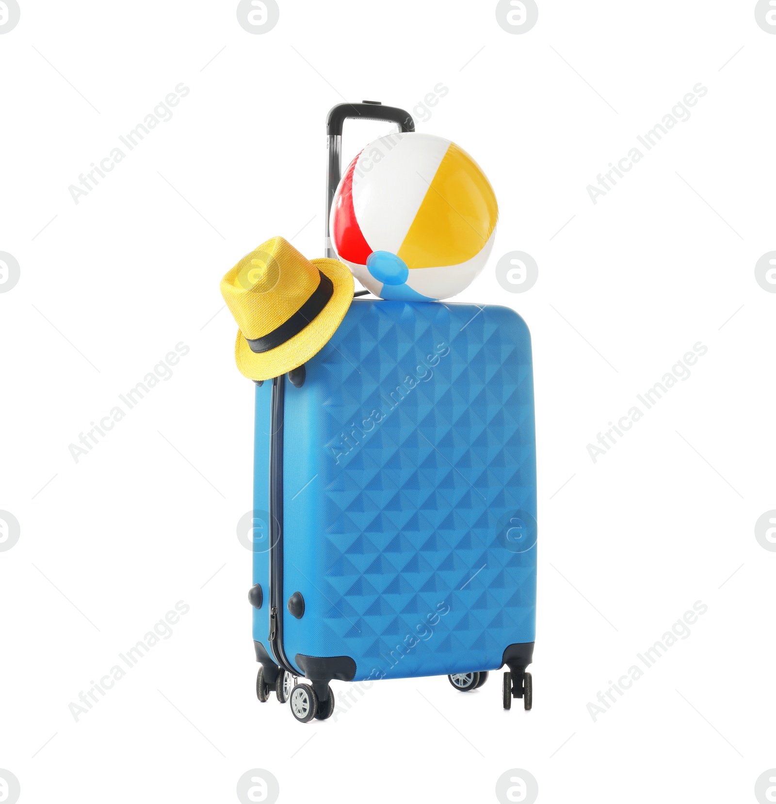 Photo of Blue suitcase with hat and inflatable ball packed for journey on white background