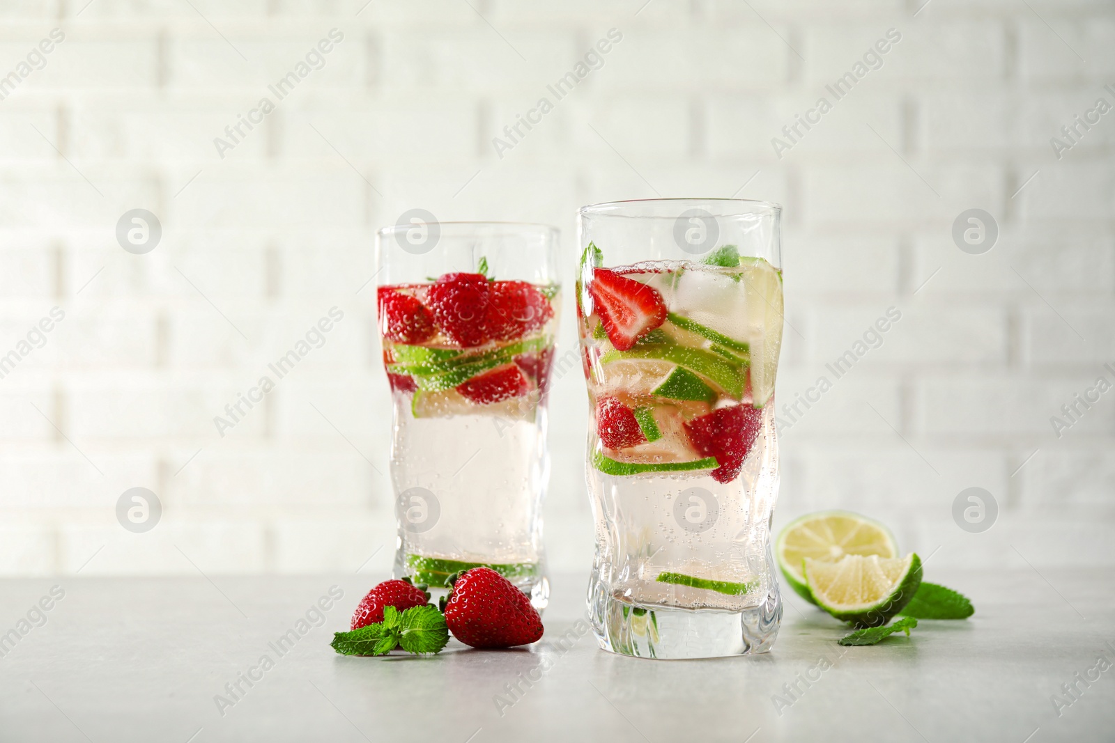 Photo of Tasty refreshing drink on light grey table