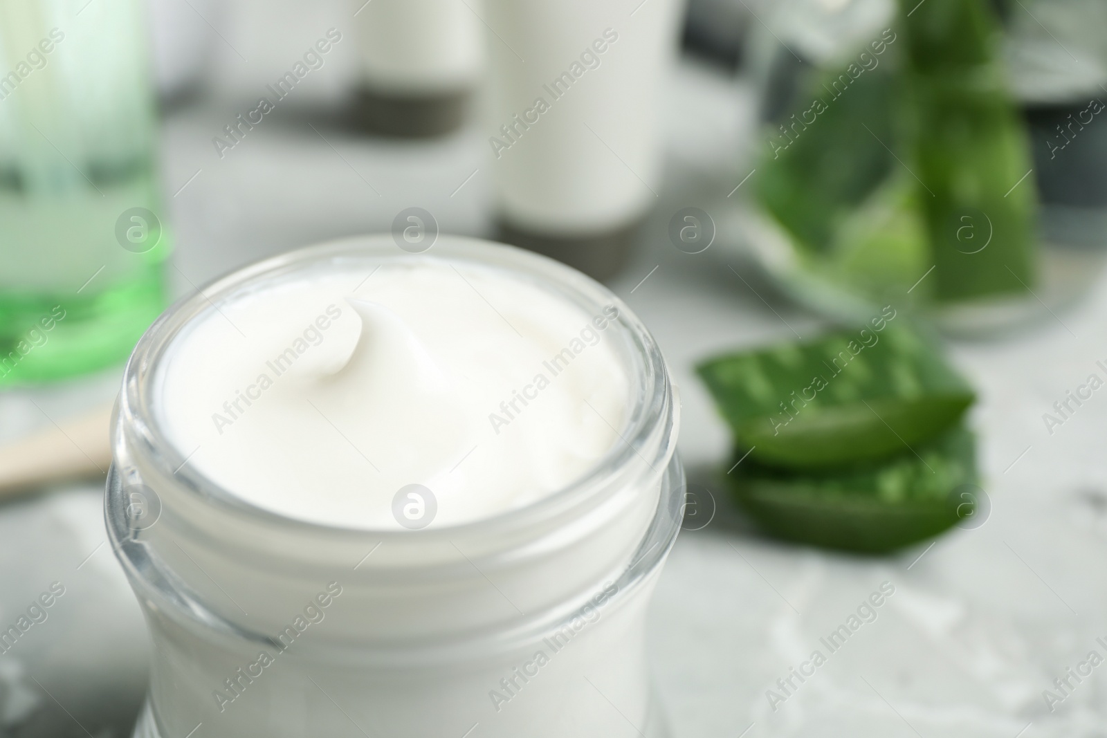 Photo of Open jar of aloe cream on table, closeup. Organic cosmetics