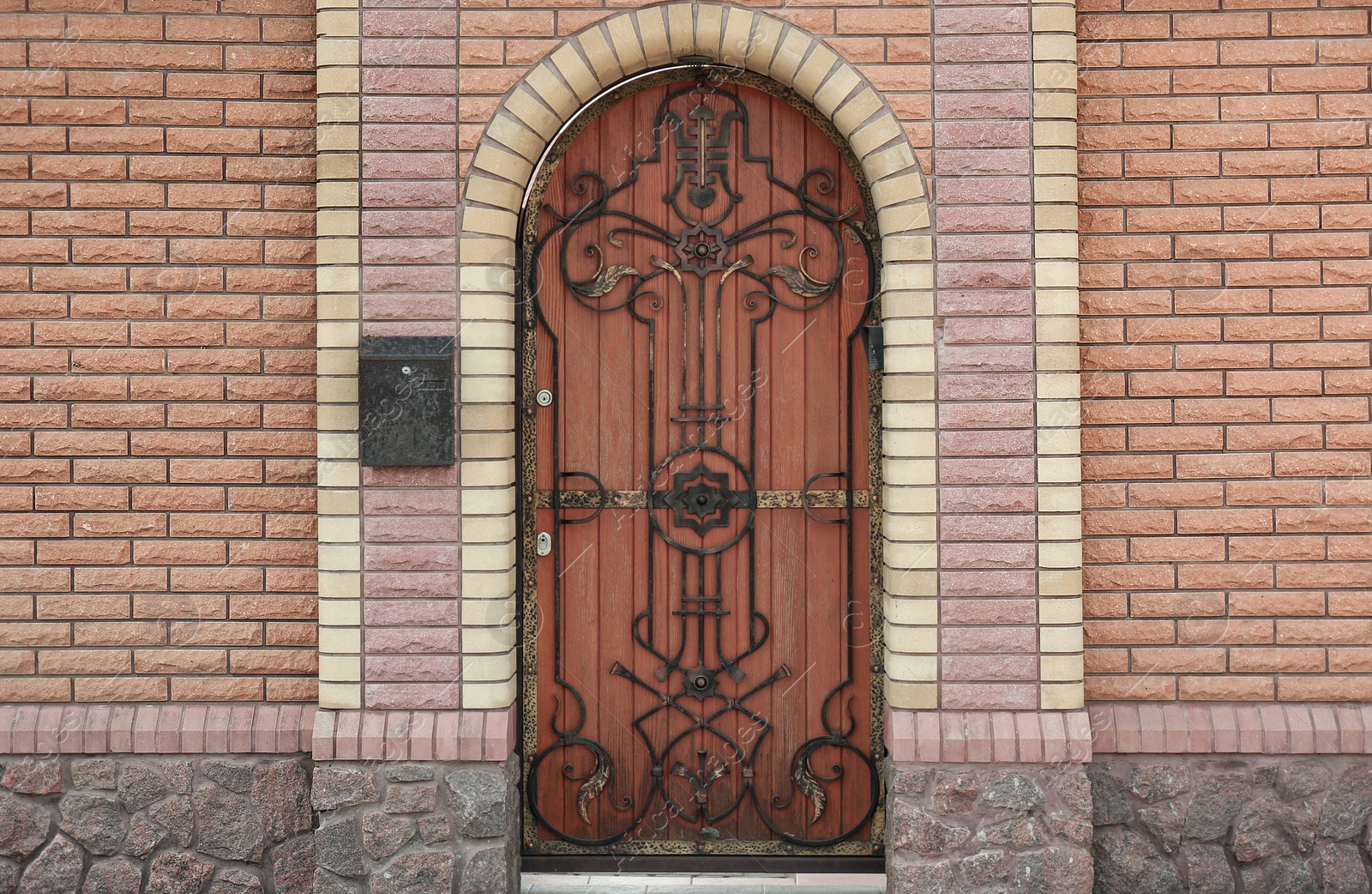 Photo of Building entrance with ornate arched wooden door